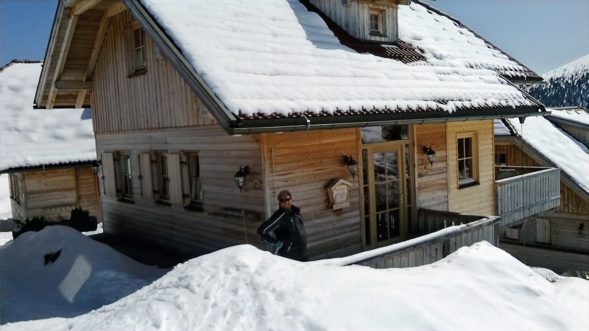 Ferienhaus Veilchens Bau aus Holz mit schneebedecktem Dach im Winter am Falkertsee